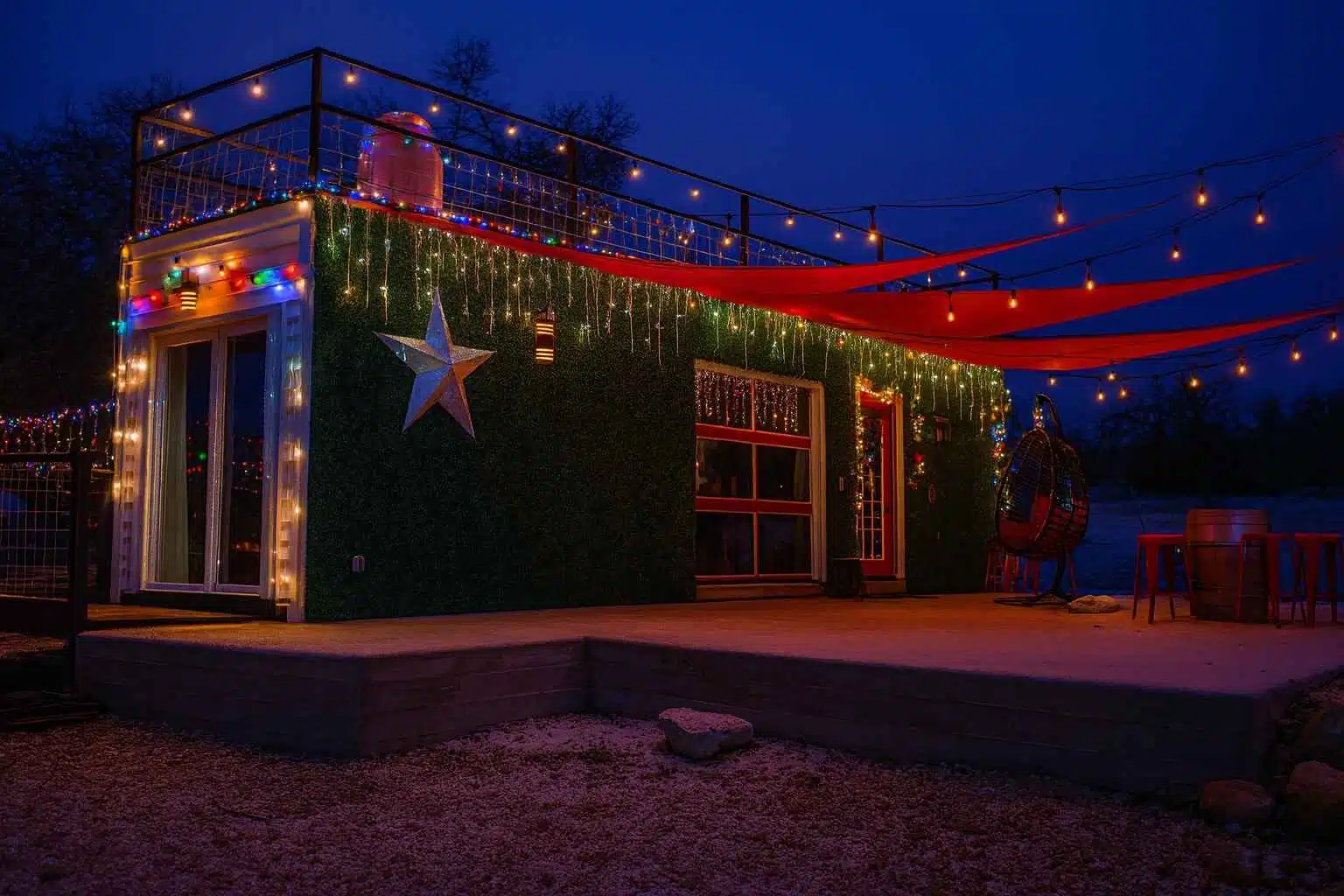 A small building with a green wall and christmas lights at night
